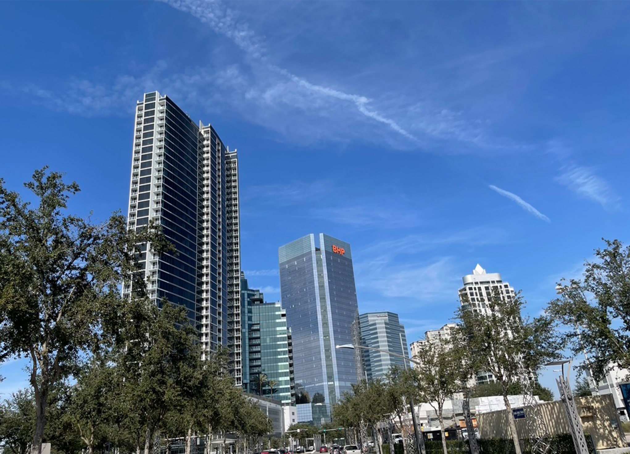 Houston high-rise towers along Post Oak against a blue sky